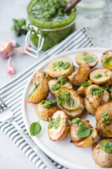 Baked potatoes in rustic style with green pesto sauce