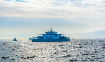 Muslim architecture and water transport in Turkey - Beautiful View touristic landmarks from sea voyage on Bosphorus. Cityscape of Istanbul at sunset - old mosque and turkish steamboats, view on Golden
