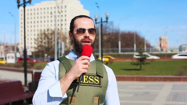 A successful reporter is a man in a bulletproof vest with a microphone in his hands, live on the street, an alarming report.