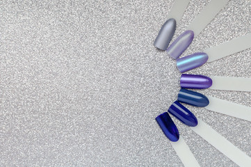 Nail art color palette. Set of blue, violet and lilac artificial nails and manicure samples, on a...