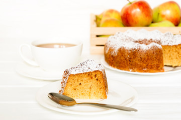 Morning still life with cake with icing served tea and raw apples on white table. Selected focus