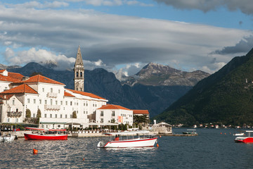 Fototapeta na wymiar Beautiful view of the old coastal town of Perast in Montenegro with beautiful architecture, the sea and boats on the background of the mountains.