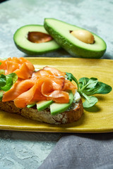 On a light gray background is a yellow plate with brockett. Beautiful serving of dishes. Restaurant menu