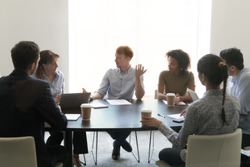Diverse employees negotiate brainstorming in conference room