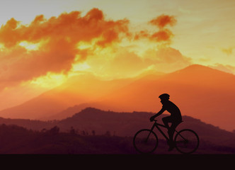 Fototapeta na wymiar silhouette bike and mountain at sunset background
