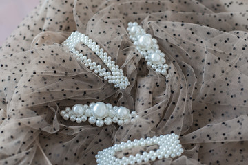 four hairpins with pearls, hair ornaments with pearls, decoration with pearls on brown background  (horizontally, with space).