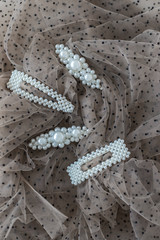 four hairpins with pearls, hair ornaments with pearls, decoration with pearls on brown background  (vertically, with more place)