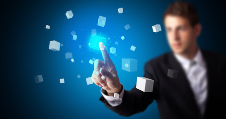 Man touching hologram screen displaying cube symbols
