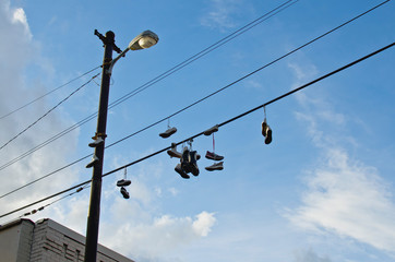 A lot of shoes hanging from the power lines in the back city streets. 