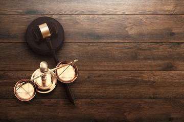 Judge's gavel and scales on wooden background, top view, flat lay. The concept of justice, punishment, judge, corrupt court. copy space