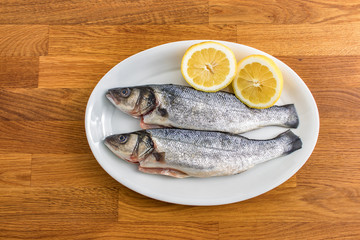 two fresh sea bass with lemon