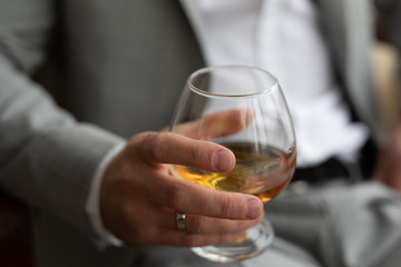 a glass of whiskey in the hands of a man