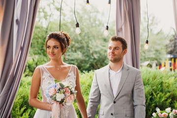Beautiful wedding couple. The bride and groom are standing at the wedding ceremony. The bride in a...