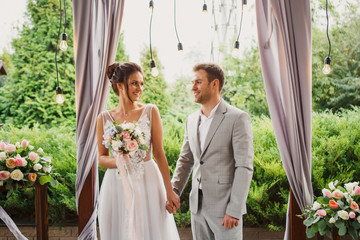 Beautiful wedding couple. The bride and groom are standing at the wedding ceremony. The bride in a...