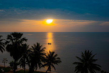 Fototapeta na wymiar Silhouette fishing boat on skin sea water color gold at sunrise time.