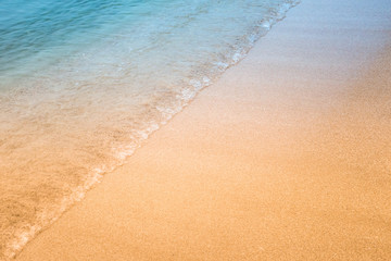 Soft wave of blue ocean on sandy beach.