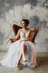 Fototapeta na wymiar portrait of a young beautiful wedding bride in a beautiful stylish dress on a gray background