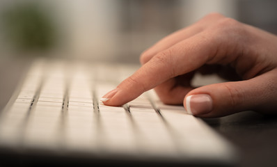 Hand typing on keyboard with office concept
