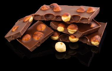 milk chocolate pieces with nuts on a dark background
