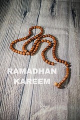 A tasbih (rosary beads) against wooden background. Islamic concept