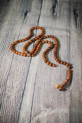 A tasbih (rosary beads) against wooden background. Islamic concept