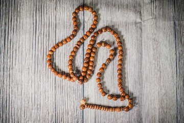 A tasbih (rosary beads) against wooden background. Islamic concept