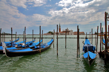 Fototapeta na wymiar Venice, Veneto / Italy: Gondolas in front of the Palazzo Ducale with San Giorgio Maggiore Church in the distance
