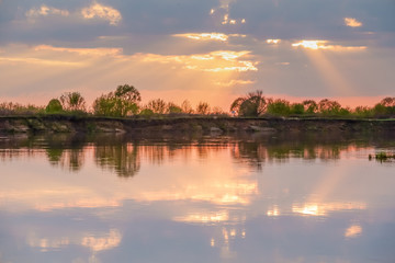 Sunset in the lake. beautiful sunset behind the clouds above the over lake landscape background. Summer