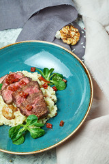 White rice with beef. Rizzotto. Gray light textured background. Beautiful serving of dishes
