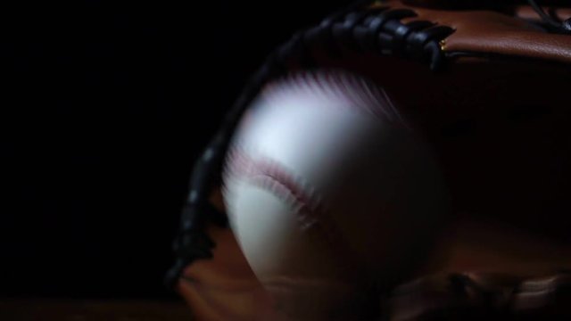 Throw a baseball with a baseball glove, put in a dark light footage slow motion