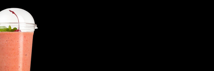 Delicious fruit cocktail in a plastic cup, on a black background. Smoothie Banner.