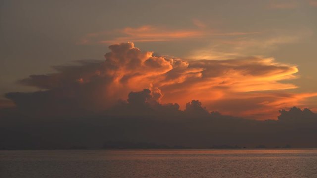 Storm clouds during sunset. Colorful sunset over calm sea water near tropical beach. Summer vacation concept. Island Koh Phangan, Thailand