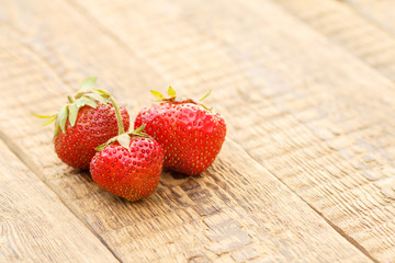 Bunch of ripe strawberries on old wooden boards.