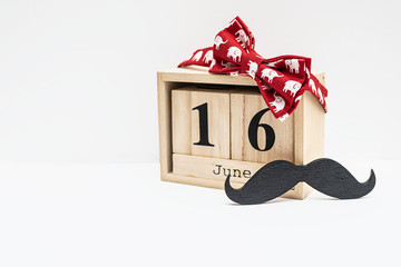 Festive composition for Father’s Day 2019 with wooden calendar, red bow tie, wooden mustache on...