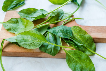 Fresh Baby Spinach Leaves on Wooden Board.