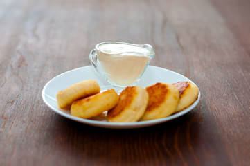 Fried cheesecakes with sour cream top and side view. For cafe or restaurant menu design.