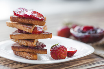 Morning breakfast. Toasts with strawberry and jam. Bread and confiture. Fresh hot toasts with cream. Delicious homemade dessert.