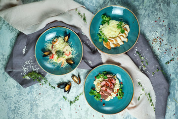 Blue plates with risotti. Gray light textured background. Beautiful serving dishes. Restaurant menu