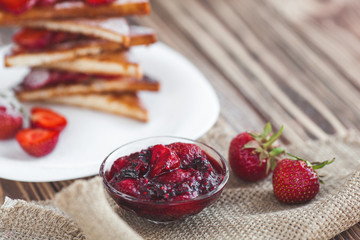 Morning breakfast. Toasts with strawberry and jam. Bread and confiture. Fresh hot toasts with cream. Delicious homemade dessert.