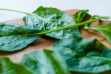 Fresh Baby Spinach Leaves on Wooden Board.