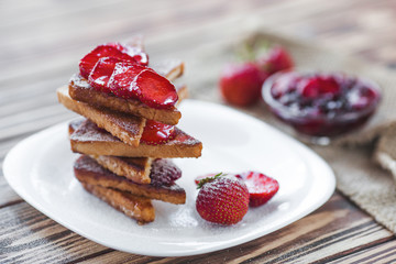 Morning breakfast. Toasts with strawberry and jam. Bread and confiture. Fresh hot toasts with cream. Delicious homemade dessert.