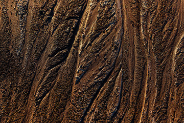 abstract mud background with water washout trails and selective focus