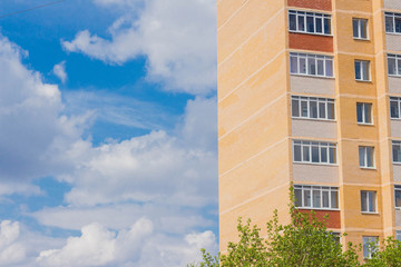 multi-storey residential building on blue sky and clouds background