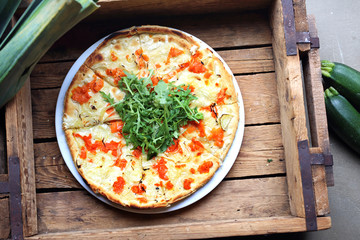 Pizza on a crispy thin crust with tomatoes, mozzarella and rocket salad.