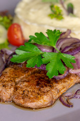 Gegrilltes Schweinesteak mit Zwiebeln