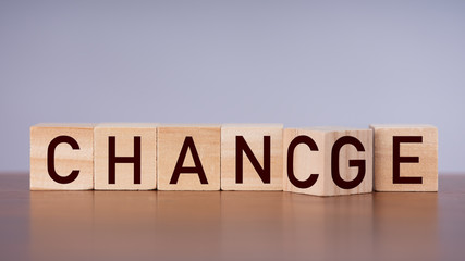 Wooden cube flip with word "change" to "chance" on brown wood table, career growth or change yourself concept