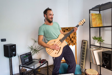 Obraz premium Musician playing electric guitar in home music studio.