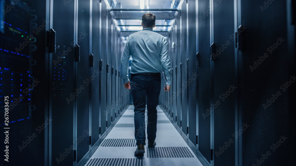 Poster IT Engineer Walking Through Data Center with Working Server Rack to Do Routine Maintenance Check with Laptop. Concept of Cloud Computing, Artificial Intelligence, Supercomputer