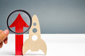 Wooden rocket and up arrow. The concept of a startup. The concept of raising fund for a startup....