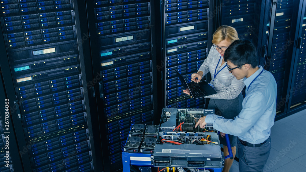 Aufkleber In the Modern Data Center: Engineer and IT Specialist Work with Server Racks, on a Pushcart Equipment for Installing New Hardware. Specialists Doing Maintenance and Diagnostics of the Database.